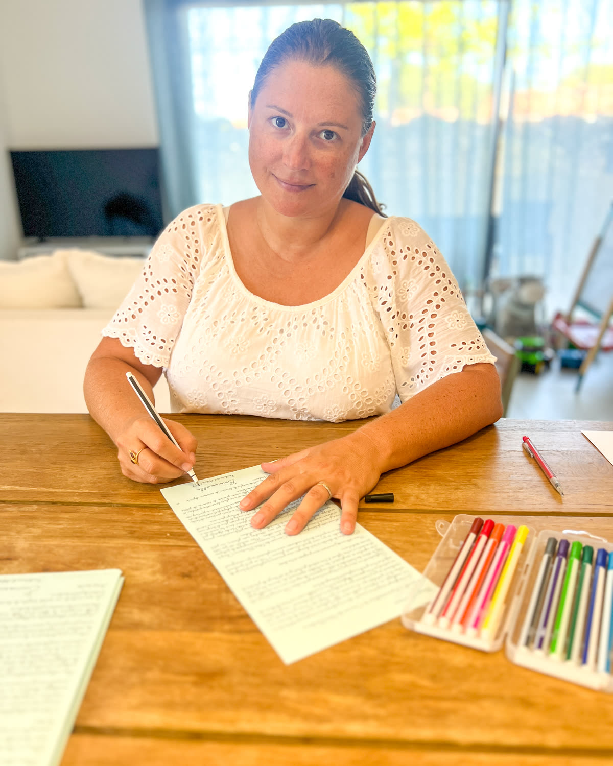 Emmanuelle, fondatrice d'Atelier 1987, à sa table en train d'écrire la lettre du Club des Petits Bonheurs